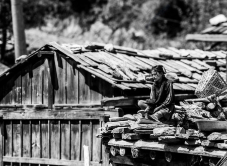 Girl Seated on a Rooftop of Stone and Wood