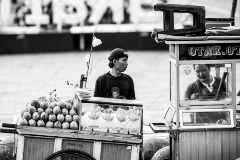 A Fruit Vendor and a Cook at their Carts