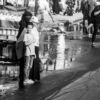 Boy and Women at the Roadside Water - street photography, urban photography, documentary photography, visual storytelling, fine art photography, light and shadow