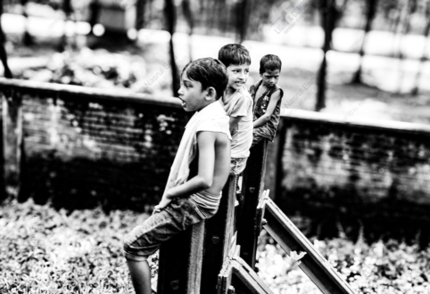 Three Boys on a Weathered Fence