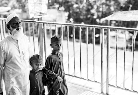 An Elder and Two Boys Beside a Railing