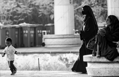 A Boy's Joyful Run Past Two Women