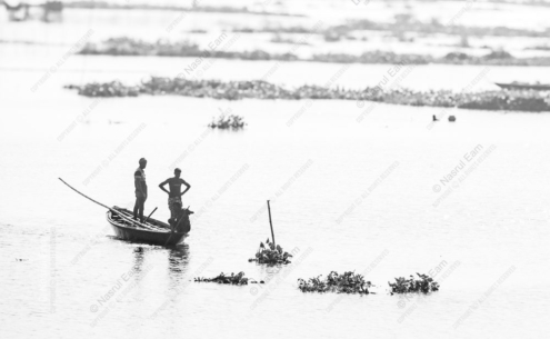 Two Men Standing in a Skiff on a Sun-Bleached River