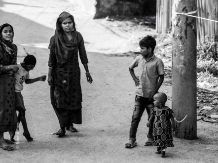 A Woman's Watchful Gaze and Children's Play on a Dusty Lane